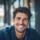 Homme souriant, cheveux bouclés, pose décontractée