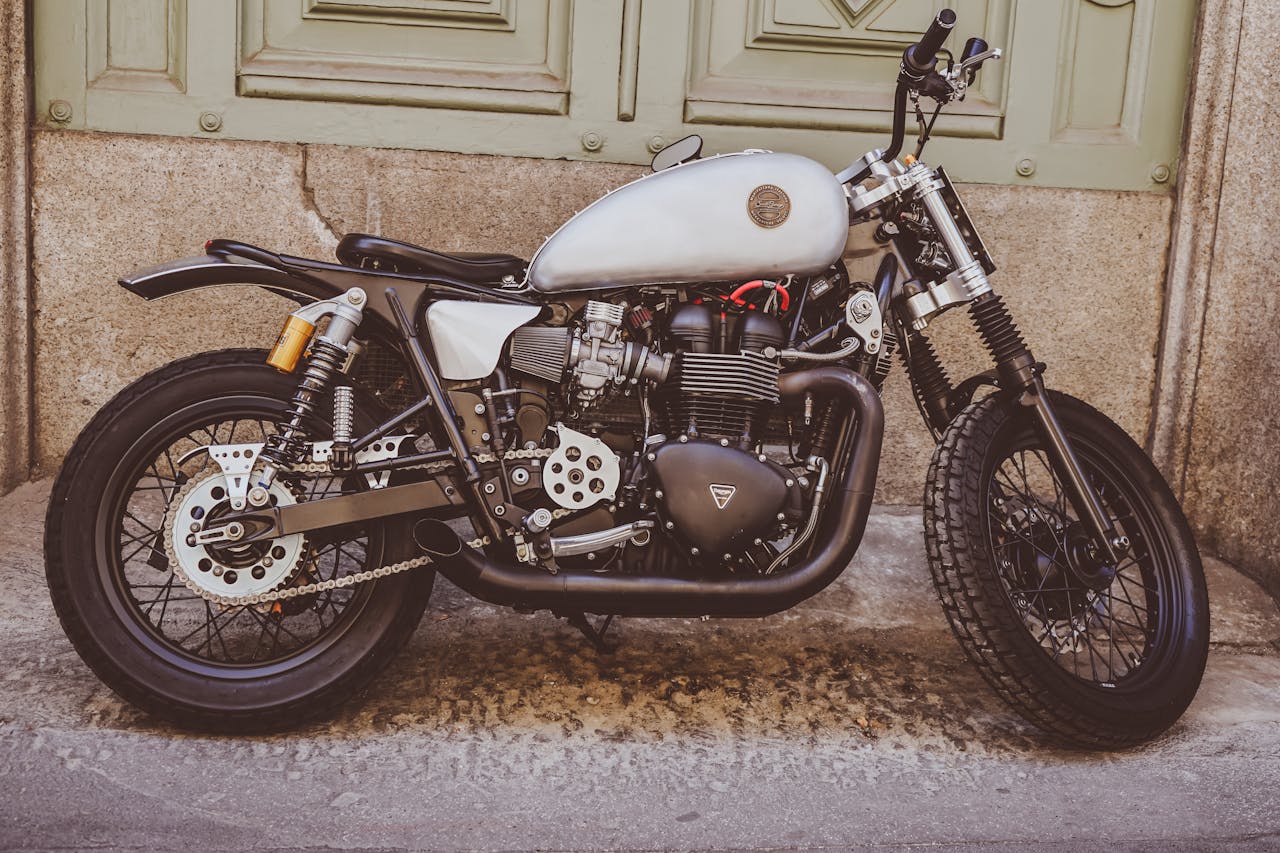 Classic motorcycle parked against a grunge wall, showcasing its sleek vintage design.